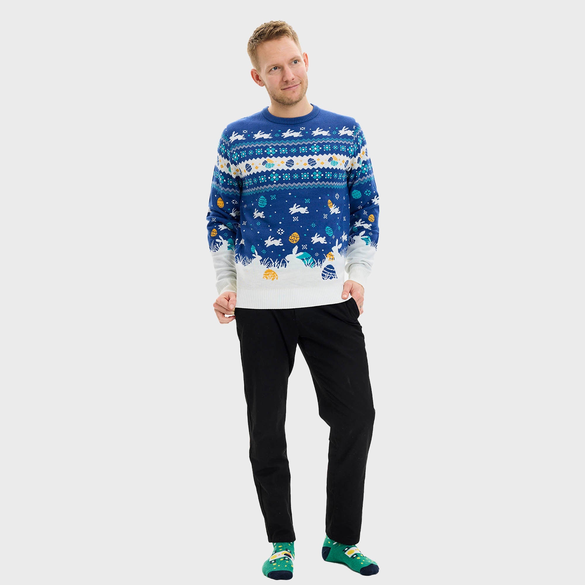 En mann og en kvinne holder rundt hverandre og har på seg en blå påskegenser med harer på.